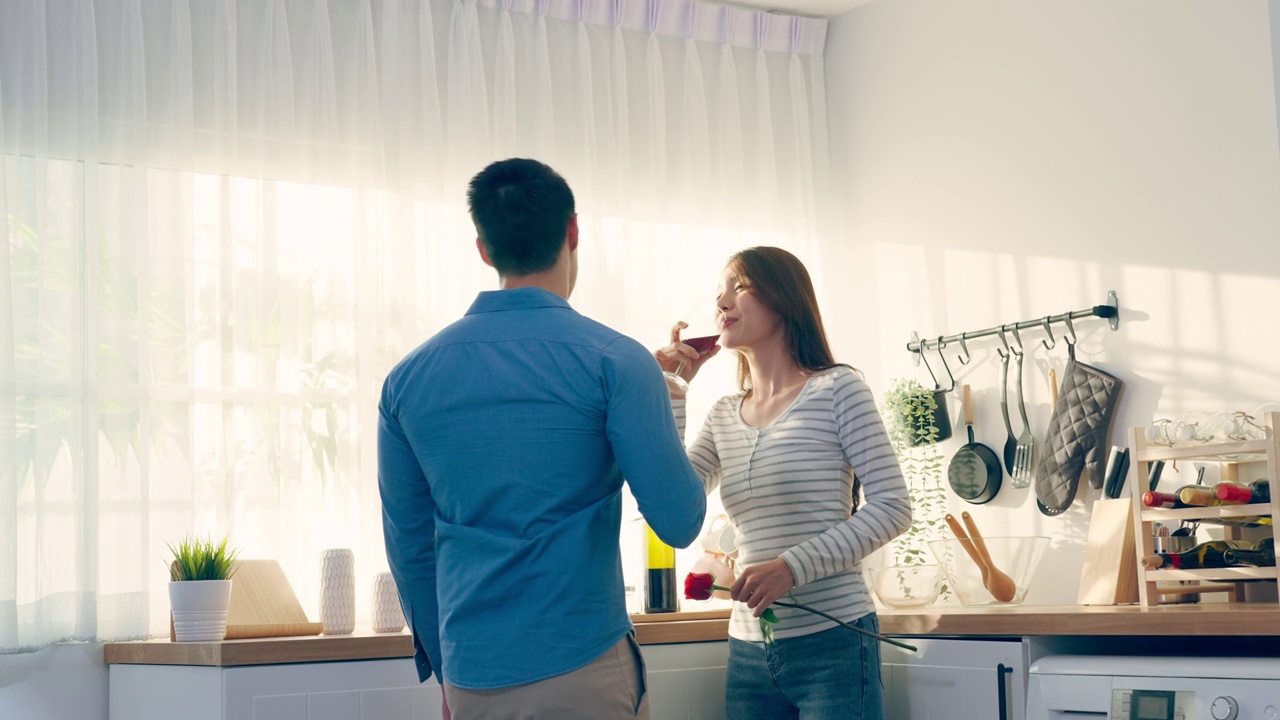 详情图-亚洲年轻情侣在情人节举杯畅饮。可爱浪漫的新婚男女在家里厨房共进晚餐庆祝结婚纪念日