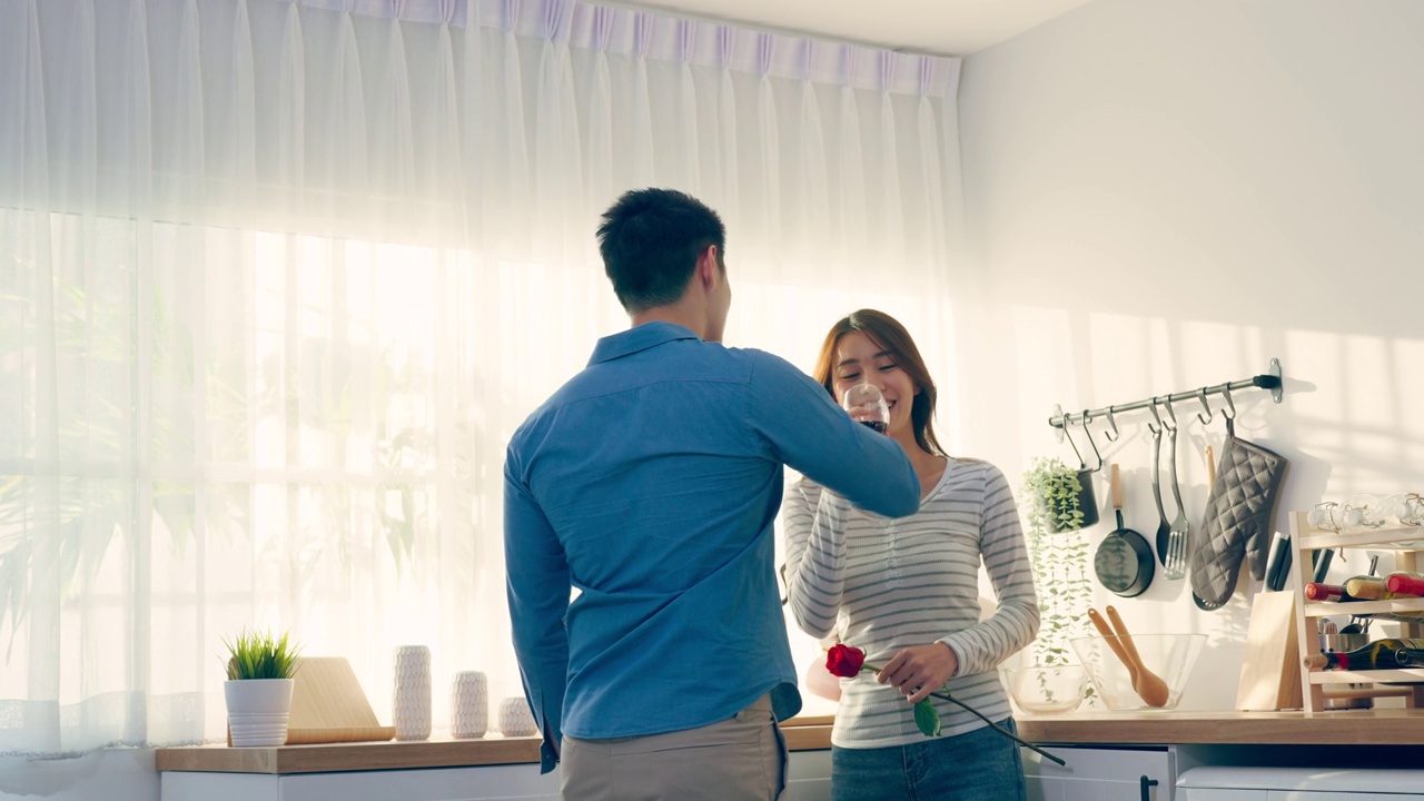 详情图-亚洲年轻情侣在情人节举杯畅饮。可爱浪漫的新婚男女在家里厨房共进晚餐庆祝结婚纪念日