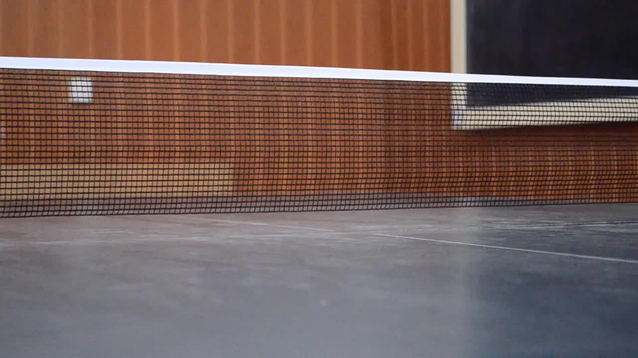 乒乓球被两个竞争对手或运动员击中时，在桌子上弹下来