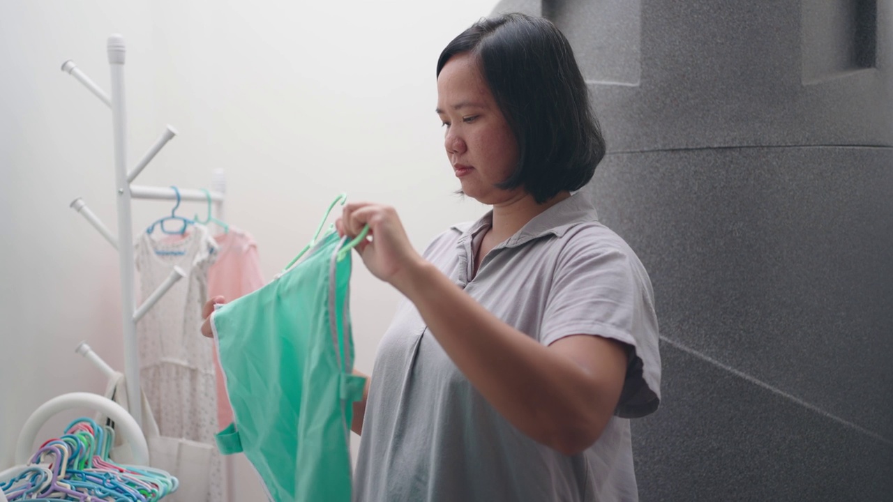 妇女在洗完衣服后挂湿衣服