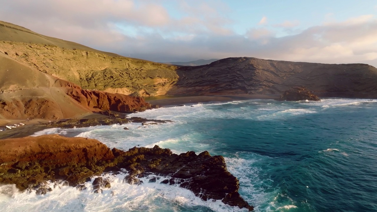 Playa el Golfo靠近el Lago Verde湖的山顶景观。兰萨罗特岛。加那利群岛。西班牙。大西洋海滩。绿湖火山起源于山区。海浪冲击着海岸。