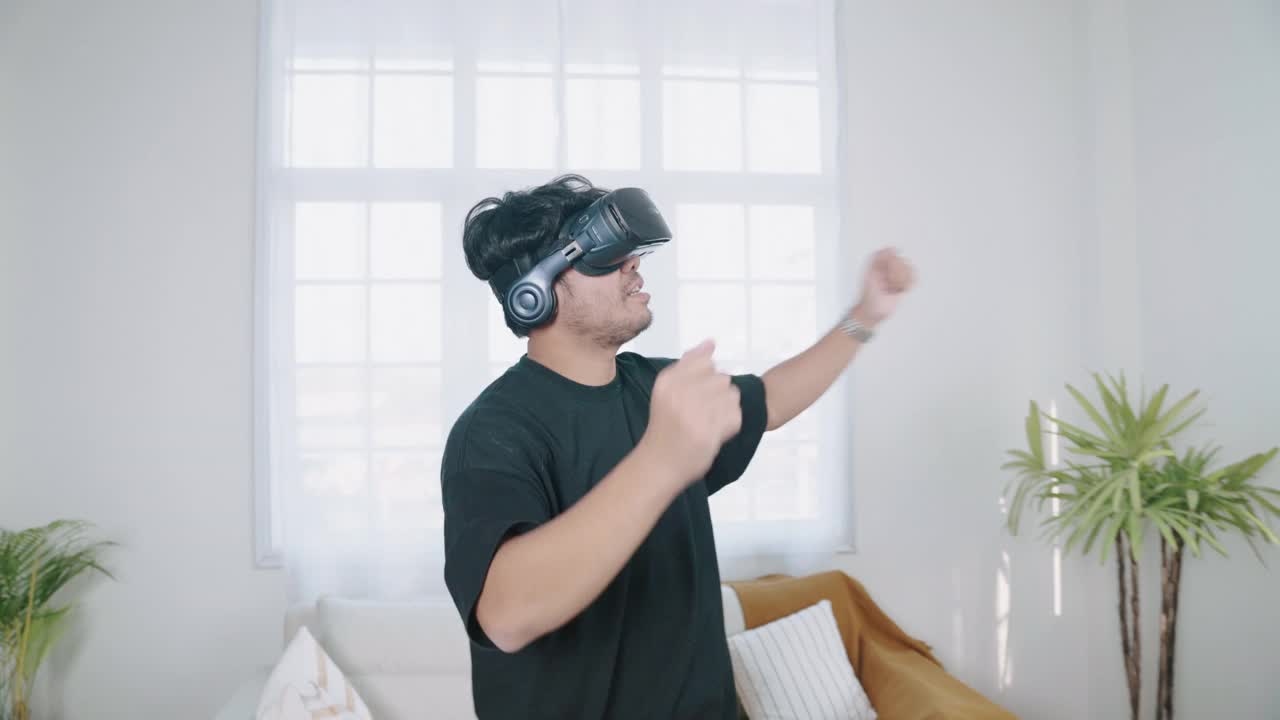 快乐的男人在家里用虚拟现实耳机跳舞