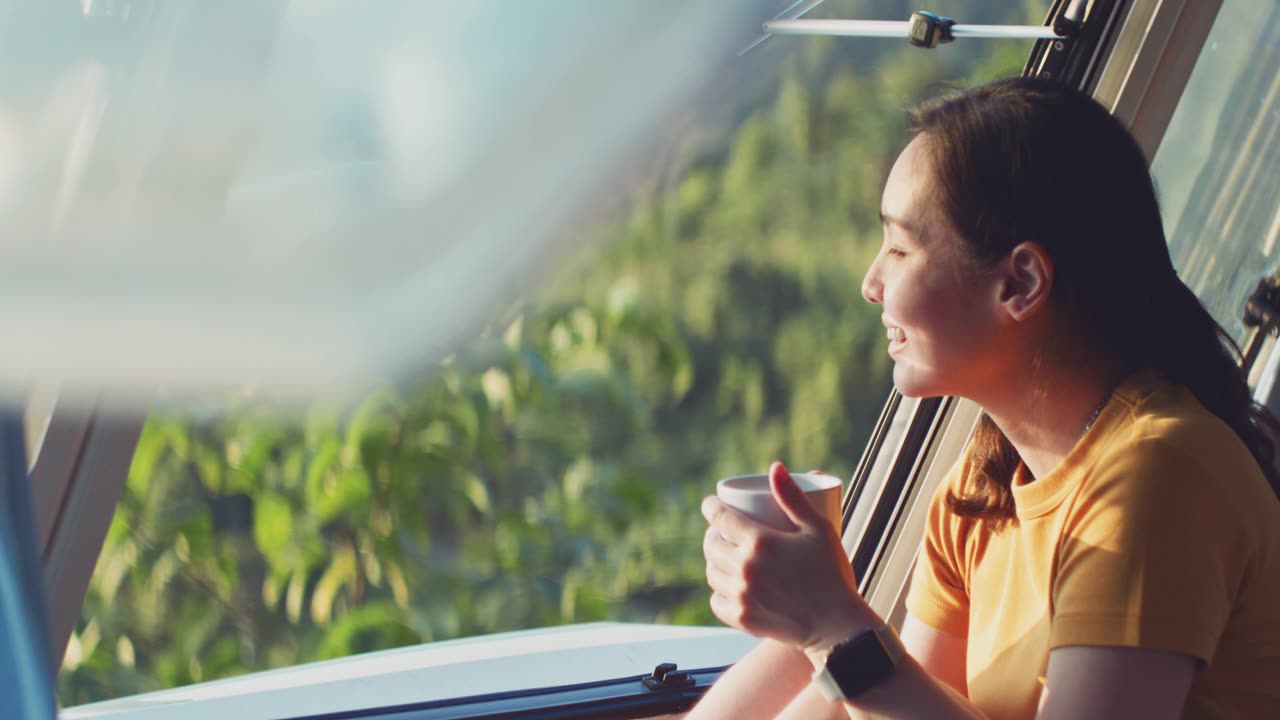 詳情圖-亞洲婦女感覺放松在露營車喝咖啡的早晨與幸福和微笑的假期