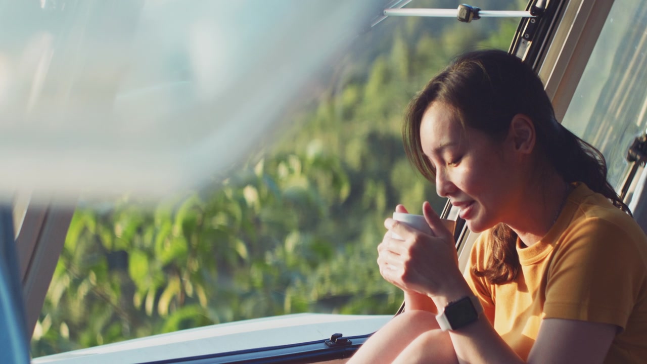 詳情圖-亞洲婦女感覺放松在露營車喝咖啡的早晨與幸福和微笑的假期