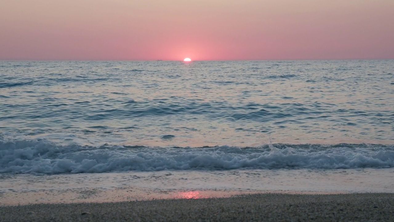 詳情圖-浪漫的海上日落背景。紫色的地平線上的天空沒有云，海浪朝著卵石灘