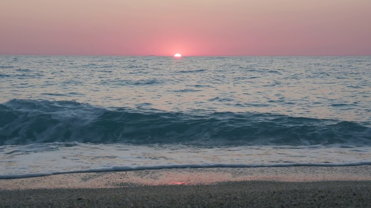 詳情圖-浪漫的海上日落背景。紫色的地平線上的天空沒有云，海浪朝著卵石灘