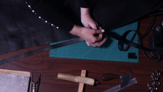 制革女工在车间切割皮革制品。皮革工匠的工作过程。视频素材模板下载
