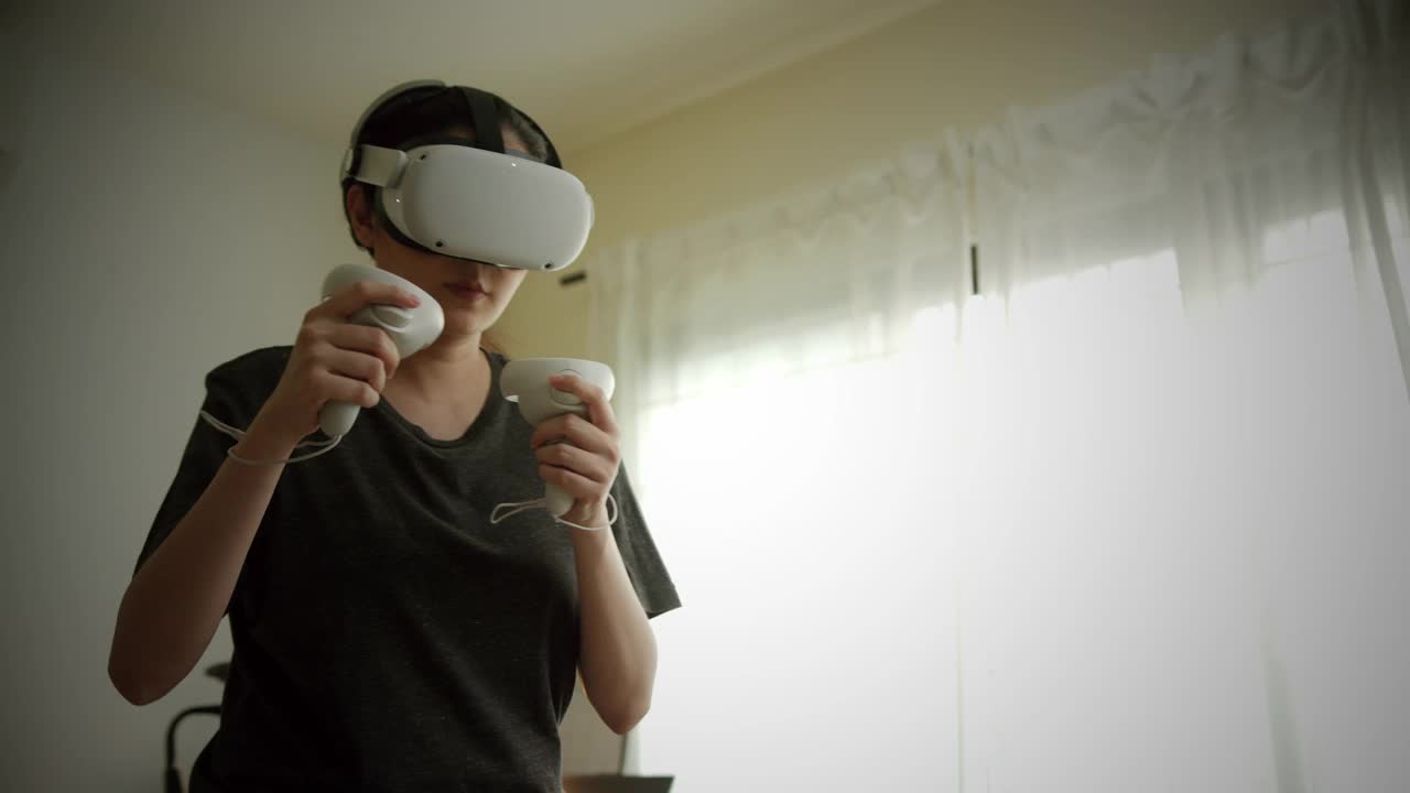 美丽的女人戴着Vr 360或虚拟现实耳机训练身体搏击拳击锻炼在家里。