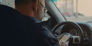 男子戴着口罩坐在车里看着屏幕上的手机短信滚动上网搜索covid新闻