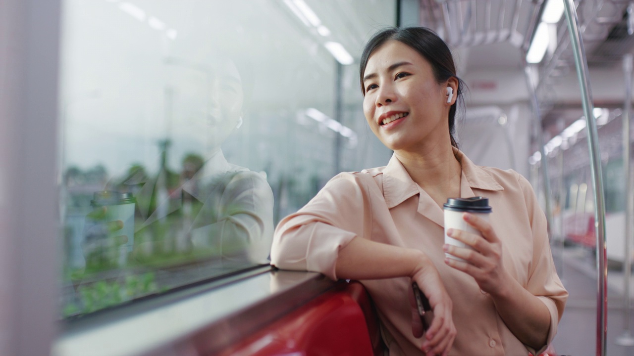 享受早晨去城市的火车，女人在去城市的火车上透过窗户看
