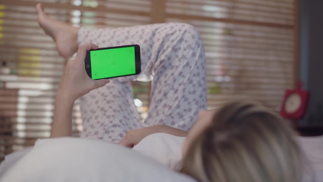 女人在床上用手机，肩膀看，视频聊天。