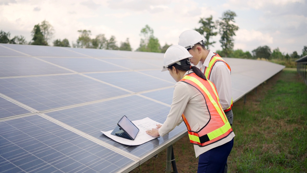 太陽能電池板電站，電氣工程師檢查建筑外的太陽能電池場。