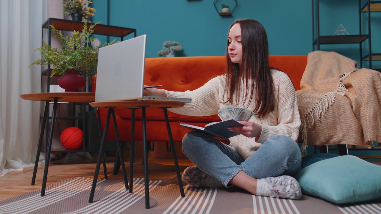 详情图-女人在做，在笔记本电脑上计划预算，数钱，女孩检查美元现金收入