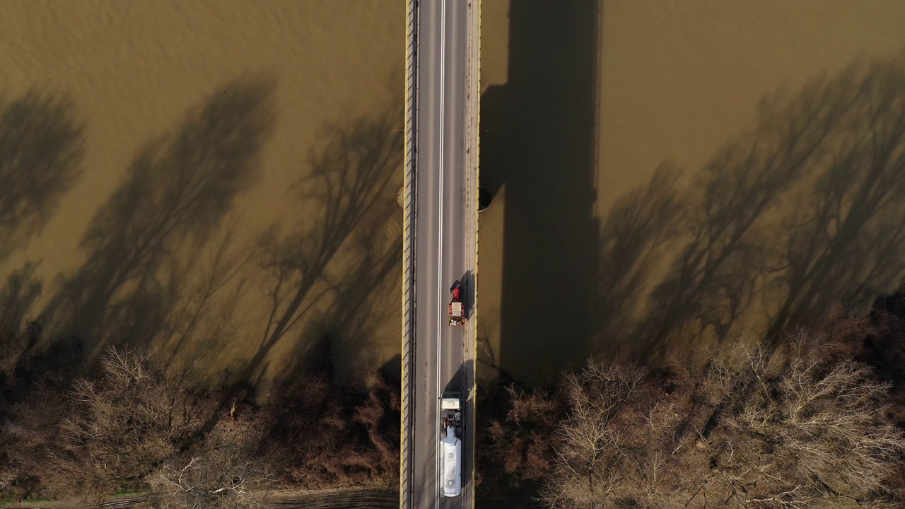 不同的车辆通过大桥横跨河流，鸟瞰图
