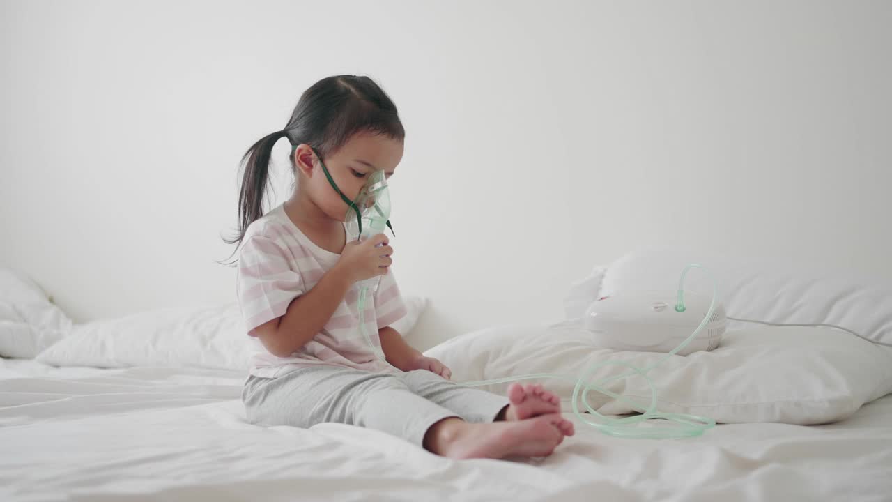 生病的小女孩用吸入器呼吸，喷雾器治疗