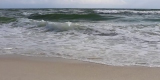 海岸的海浪拍打在沙滩上