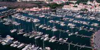 航拍的葡萄牙旅游小镇Quarteira。
欧洲大西洋沿岸住宅区附近有许多游艇和海船的港口。无人驾驶飞机射击。
