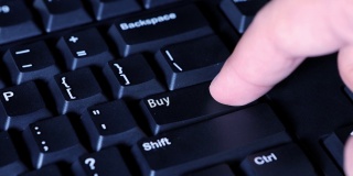 人体手指按下电脑键盘上的买入键的宏。网上购物的概念