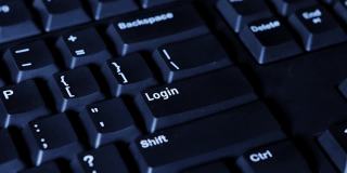 一名男子的手按下电脑键盘上的登录按钮的宏观视频片段