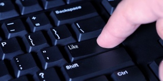 一个男人的手按一个类似的按钮在计算机键盘上的特写