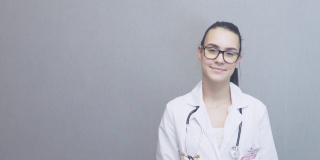 肖像微笑的年轻女医生白色制服听诊器复印空间灰色