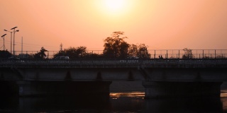 纳尔默达运河桥在日落在甘地那格-艾哈迈达巴德路，艾哈迈达巴德，古吉拉特邦，印度。过桥车辆。