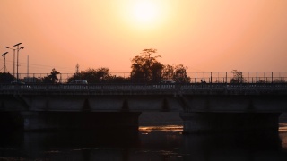 纳尔默达运河桥在日落在甘地那格-艾哈迈达巴德路，艾哈迈达巴德，古吉拉特邦，印度。过桥车辆。