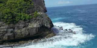 蓝绿色的海浪撞击着岩石，努沙佩尼达巴厘岛