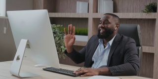 非裔美国成熟商人高管挥着手，使用笔记本电脑进行视频会议、电话虚拟会议、专业培训谈判、远程办公在线办公。视频会议