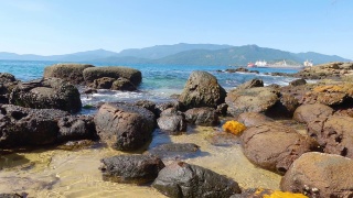 海浪撞击着岩石。背景是沙滩上的石头和大海的美丽景观视频。海和石头的背景。夏天的海浪。美丽的地方,旅游