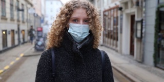 一个戴着外科口罩保护自己免受covid-19感染的女孩的肖像