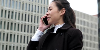 中国企业家在摩天大楼旁用手机讲话