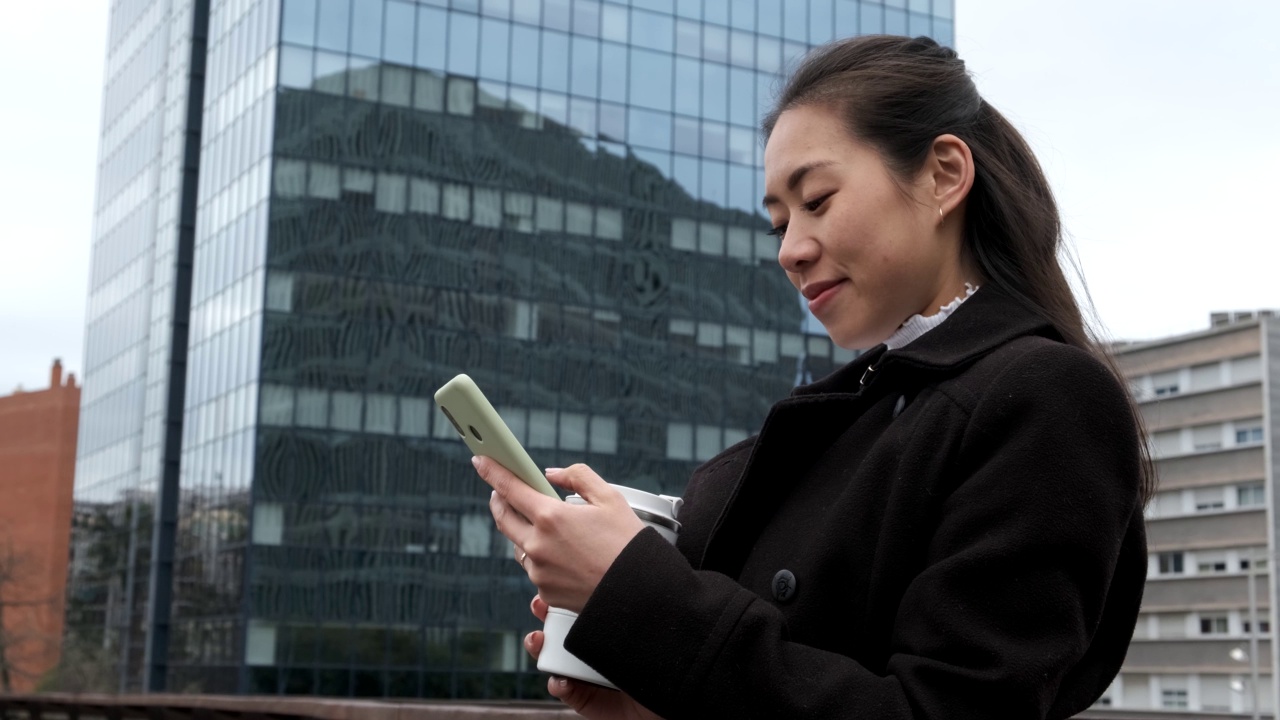 亚洲女商人在市中心用智能手机