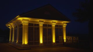 有柱子的有顶阳台在晚上被灯光照亮。