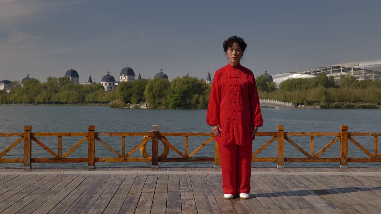 一个女人在湖边练习太极拳。