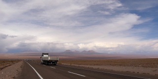 沙漠景观中的高速公路，一辆经过的卡车