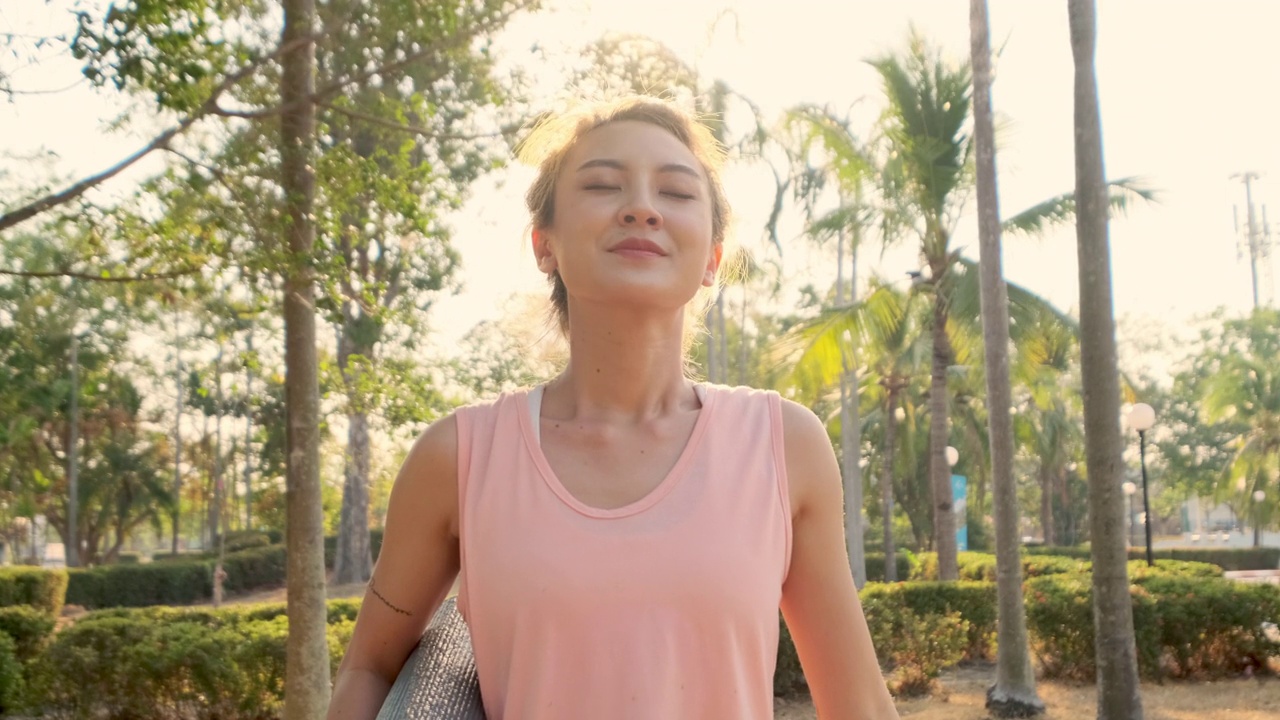 詳情圖-新常態(tài)健康生活理念。一名年輕的亞洲女性從COVID-19疫情中康復(fù)后，摘下醫(yī)用口罩，在公園室外練習(xí)瑜伽。