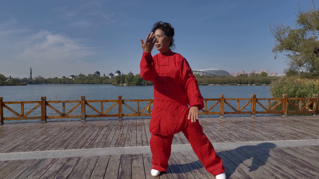 一个女人在湖边练习太极拳。