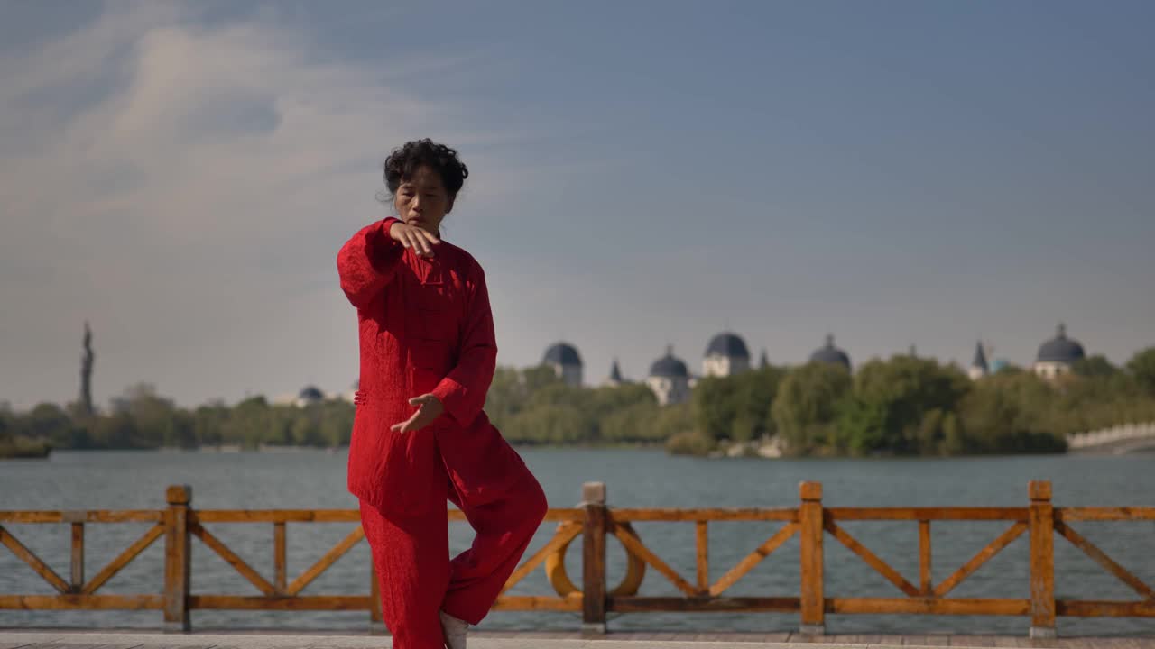 一个女人在湖边练习太极拳。