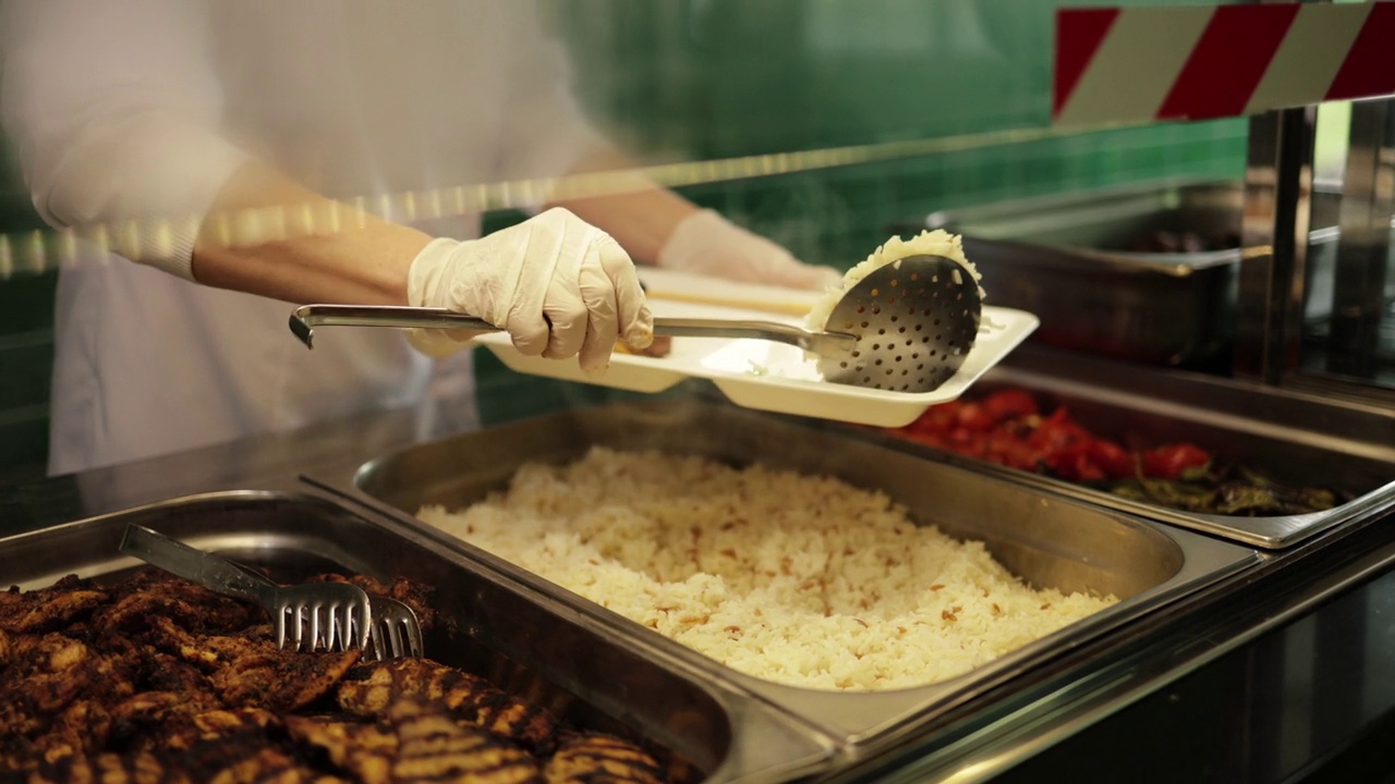 厨师把她在食堂做的米饭和鸡肉供应给工厂的员工，从餐饮餐桌、自助餐沙拉吧、