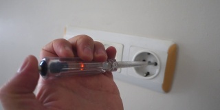 一个电工用一支电控笔测量插座里的电量，