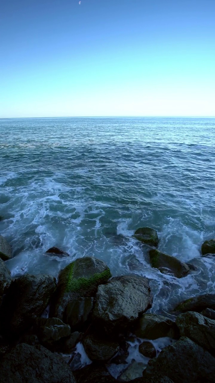 清晨在岩石海岸上掀起海浪