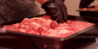 售货员将红色生肉放入托盘进行橱窗展示的特写镜头