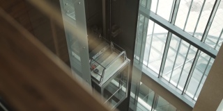 开放式玻璃透明电梯轿厢在建筑内部升起。