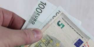 近距离观察一名男子数着一袋欧元钞票。物价上涨或经济成功的概念