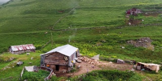 空中拍摄的4K镜头，在高原上用木头和石头建造的房子。