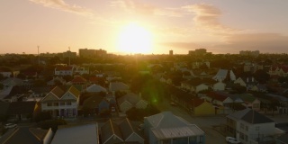 向前飞的住宅发展在城市街区。在五彩缤纷的日落天空下观看。南非伊丽莎白港