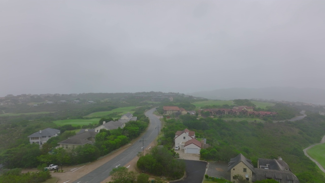 飞越豪华的住宅区，沿路的房屋。周围景物朦胧。南非伊丽莎白港