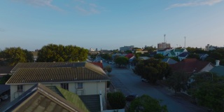 在住宅区的屋顶上低空飞行。沿街的低矮家庭房屋。南非伊丽莎白港