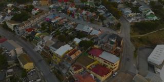 黄昏时分，在色彩斑斓的房屋和屋顶上飞翔。城市住宅发展。南非伊丽莎白港
